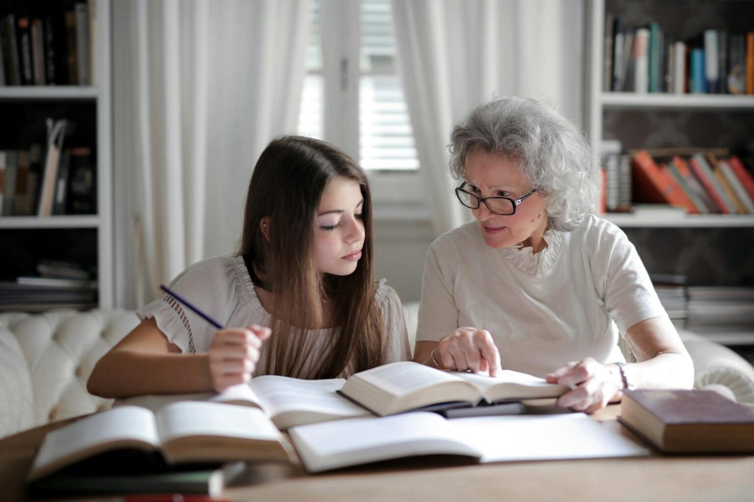 Aide aux devoirs : une grand-mère aide sa petite-fille adolescente.