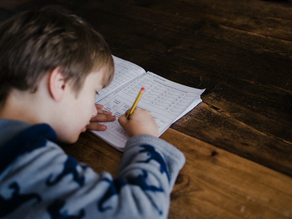 Un garçon en train de faire ses devoirs à la maison.