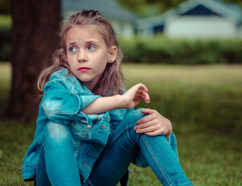 Photographie d'une fille isolée et triste, comportement associé aux troubles DYS.