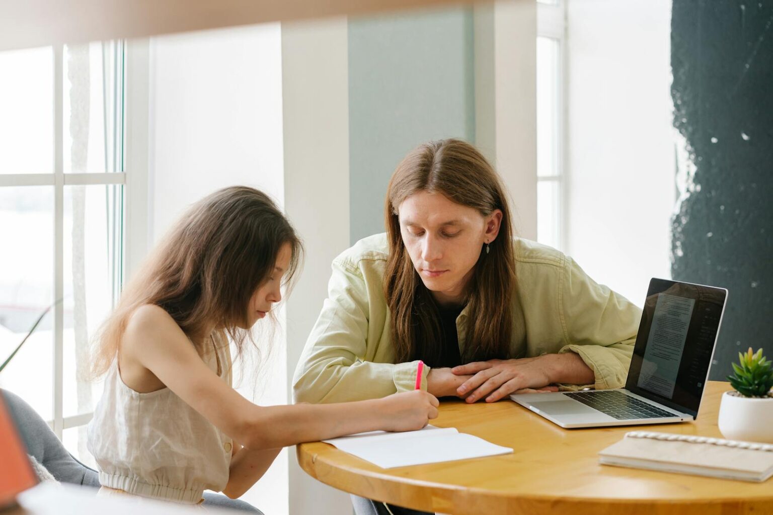 Un père pratiquant l'aide aux devoirs à domicile avec sa fille.