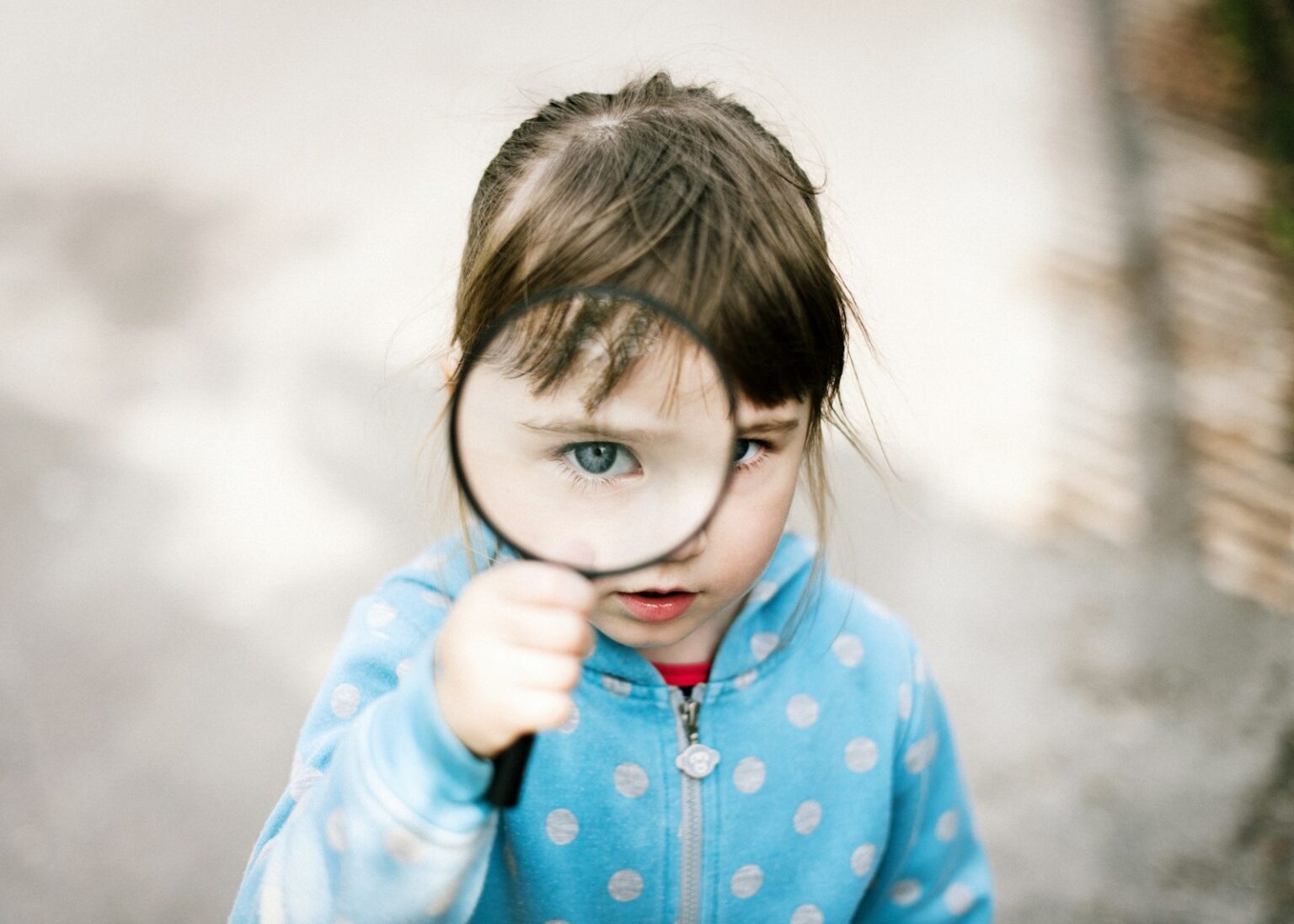 Une jeune fille tenant une loupe et illustrant le principe de la métacognition.